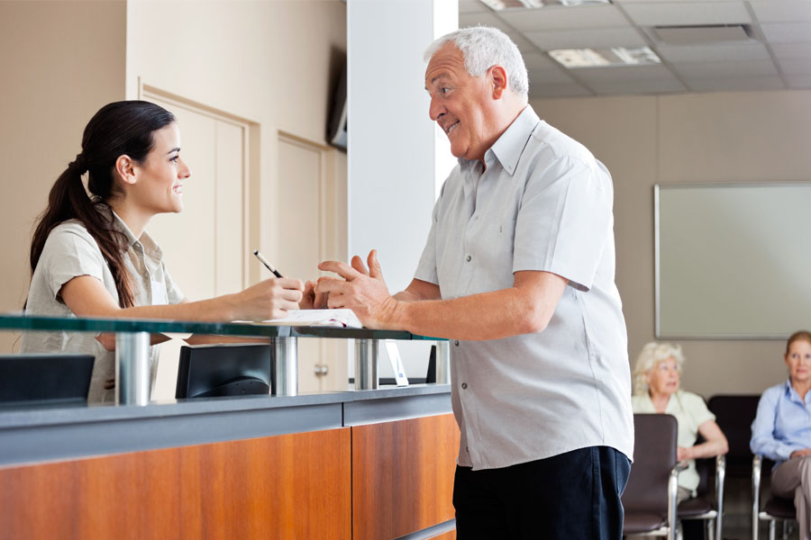 Medical Office Insurance - Receptionist and Patient Talking at the Front Desk